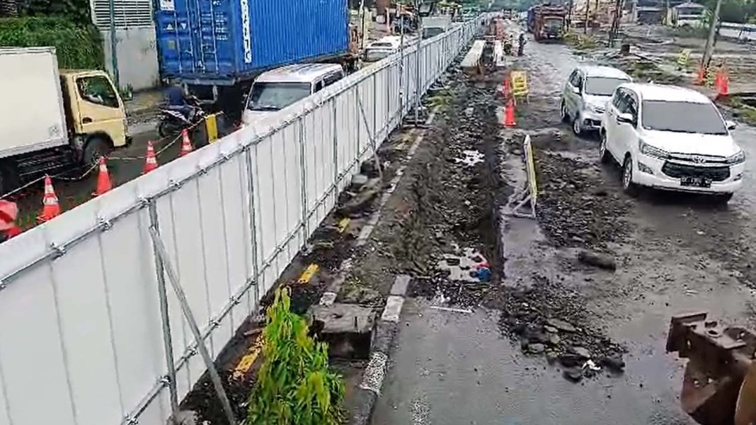 Pagar seng membatasi jalan dengan lokasi pengerjaan pembangunan Lintas Bawah (Underpass) Gatot Subroto, Medan, Sumatera Utara. Tampak sejumlah pekerja memulai pekerjaan pada Rabu (22/11/2023) pagi. Sementara di jalan tampak kendaraan mulai padat. | Lintas/HRZ