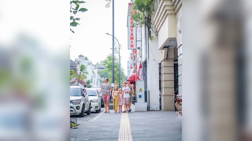 Satu keluarga wisatawan mancanegara menikmati Kota Lama Kesawan, Kota Medan, sambil berjalan di trotoar. | Dok. Kementerian PUPR