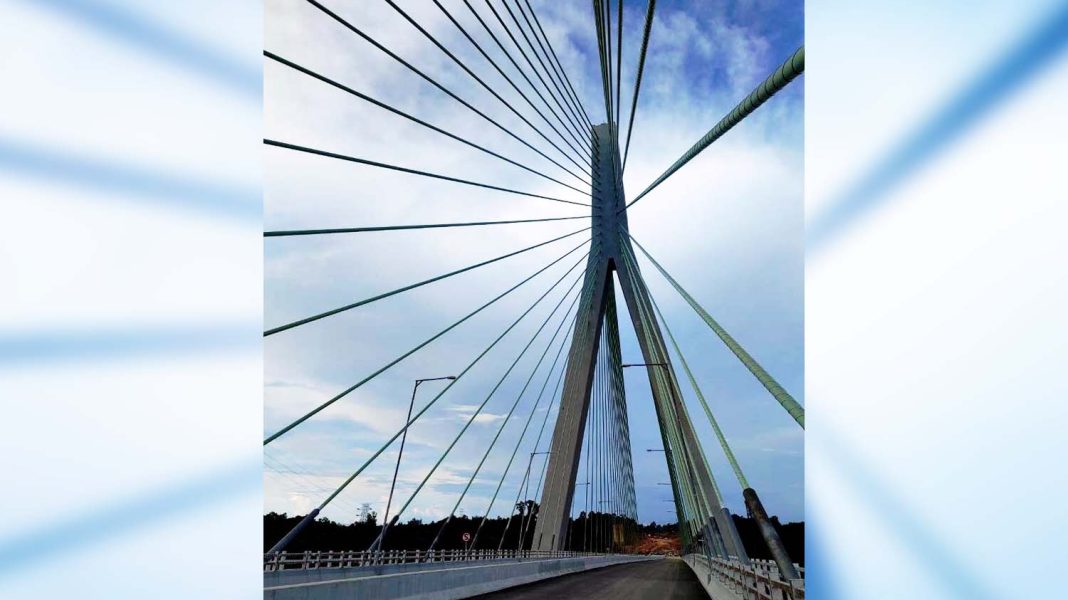 Jembatan Pulau Balang menghubungkan Kota balikpapan dan Kabupaten Penajam Paser Utara, Kalimantan Timur. Jembatan ini adalah  salah satu akses ke Ibu Kota Nusantara. Kabel-kabel penopang lantai jembatan tampak menghujam pilar penopang, seolah tembus memanah langit dan memendarkan awan dengan cahahya terang. | Majalah Lintas/Roy Afriansyah