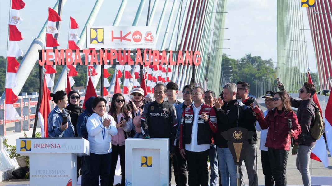 Presiden Jokowi disaksikan Ibu Negara Ny Iriana Joko Widodo, Minggu (28/7/2024), menekan sirene tanda peresmian Jembatan Pulau Balang sebagai penghubung Balikpapan dengan IKN. Tampak sejumlah artis dan pemengaruh (influezer) dari Jakarta yang ikut rombongan Presiden menyaksikan momen peresmian tersebut. | Dok. Kementerian PUPR